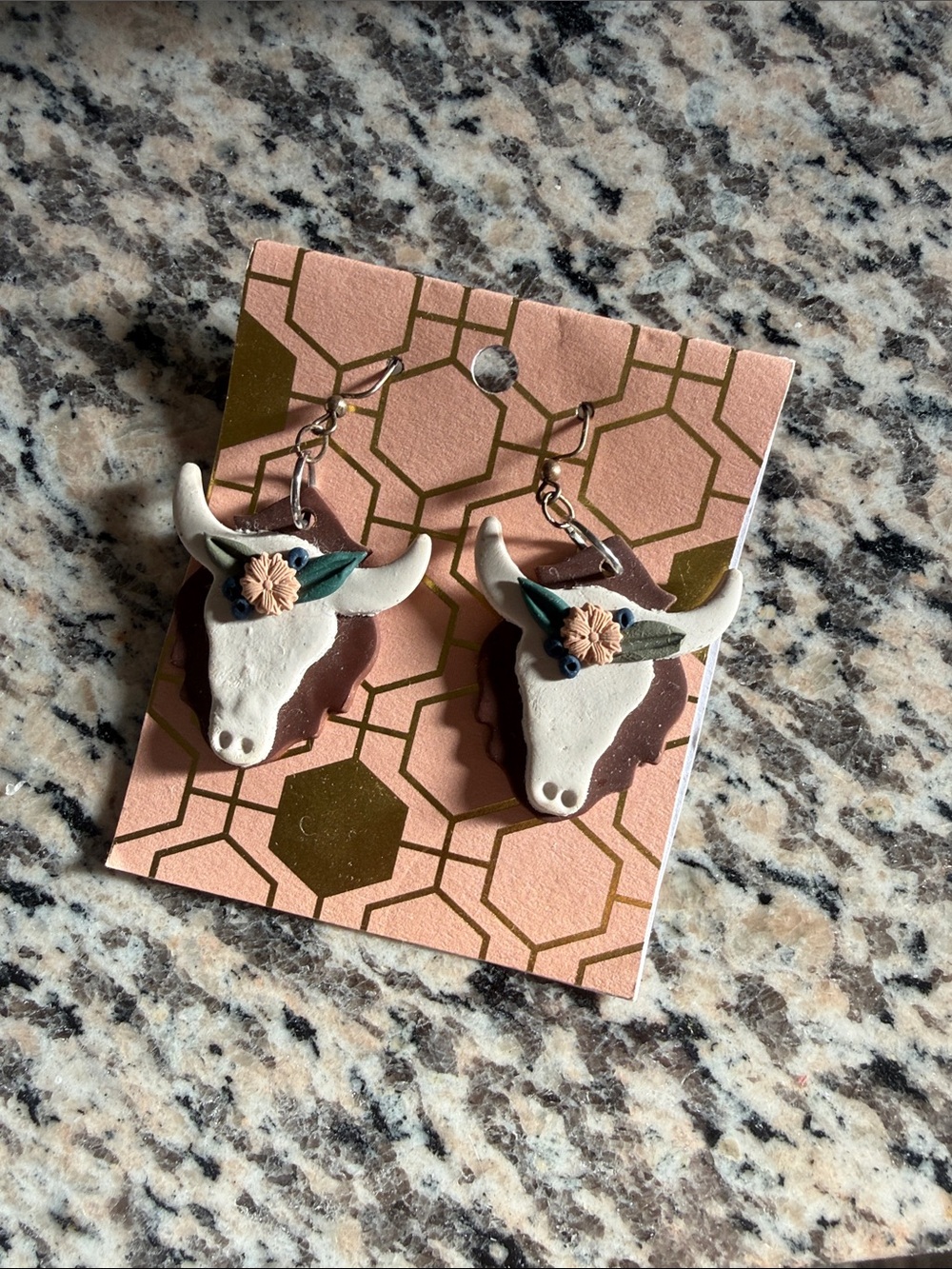 Handmade Brown and White Bull Head Earrings with Floral Accent
